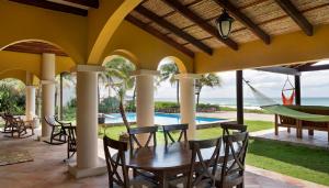 un patio con mesa, sillas y piscina en Casa Cantamar en Iguana