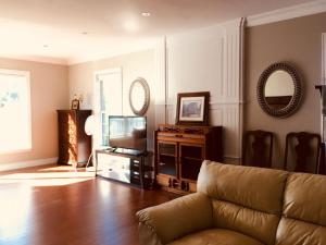 a living room with a couch and a television at Seaview White House in Stratford