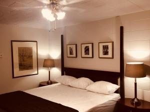 - une chambre avec un lit avec deux oreillers et deux lampes dans l'établissement Auberge Pique Nique, à Shawinigan