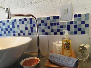 a bathroom counter with a sink and a bottle of soap at Pousada Preamare in Ubatuba