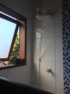 
a bathroom with a shower, sink, and toilet at Pousada Preamare in Ubatuba
