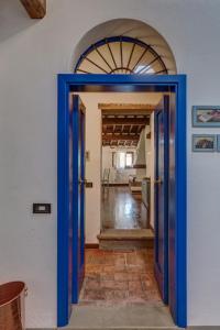 Una puerta azul que conduce a una habitación con cocina en Casa il Castello, en Gambassi Terme