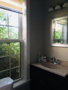 a bathroom with a sink and a mirror and a window at Seaview White House in Stratford