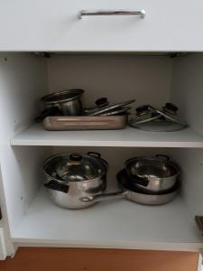 three pots and pans on a shelf in a kitchen at Apartment Dahlia Vienna in Vienna