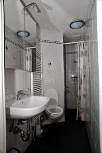 a bathroom with a white sink and a toilet at Niros Bed & Breakfast in Basel