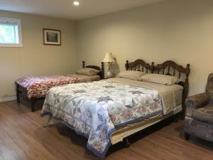 a bedroom with two beds and a chair at Seaview White House in Stratford