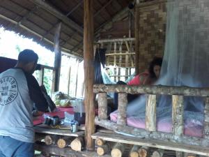 a man and a woman sitting in a bed in a hut at ORANGUTANTREKSUMATRA & LOVELY JUNGLE LODGE only book IF you are treking with us in Bukit Lawang