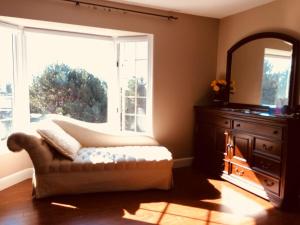 a living room with a couch and a large window at Seaview White House in Stratford