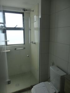 a white bathroom with a shower and a toilet at Flat de Luxo em Boa Viagem 2 Qtos in Recife