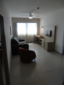 een woonkamer met een bank en een bureau bij Flat de Luxo em Boa Viagem 2 Qtos in Recife