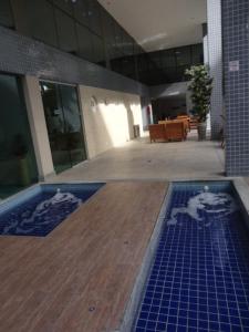 een gebouw met een zwembad met blauwe tegels bij Flat Boa Viagem Premium 2qtos in Recife