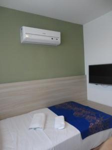 een slaapkamer met een bed en 2 handdoeken bij Flat Boa Viagem Premium 2qtos in Recife