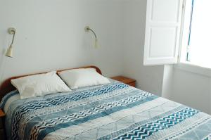 ペニシェにあるCasa da Luzのベッド(青と白のキルト、窓付)
