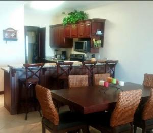 une cuisine avec une table et des chaises et une cuisine avec un comptoir dans l'établissement Oceanica Resort Flamingo, à Playa Flamingo