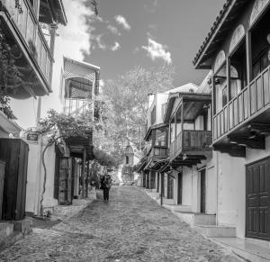a person walking down a street between buildings at Nur Hotel in Kaş
