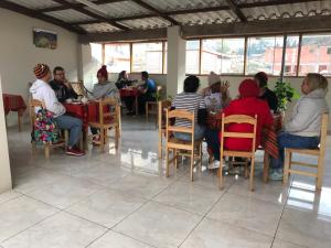 un gruppo di persone seduti a un tavolo in un ristorante di Hostal Apu Qhawarina a Ollantaytambo
