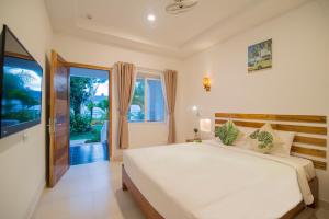 a bedroom with a white bed and a large window at Palma Resort Phu Quoc, Trademark Collection by Wyndham in Phú Quốc