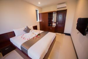1 dormitorio con 1 cama grande y TV en Gia Thành Đạt, en Quảng Ngãi