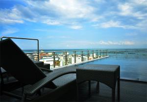 uma varanda com cadeiras e uma mesa e o oceano em One Central Hotel & Suites em Cebu