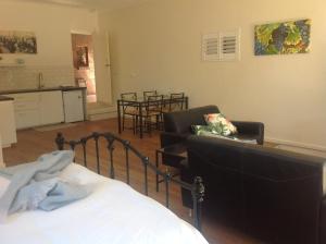 a bedroom with a bed and chairs and a kitchen at Port Elliot rural retreat in Port Elliot