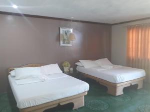 two twin beds in a room with a window at Panglao Grande Resort 邦劳美丽度假村 in Panglao Island