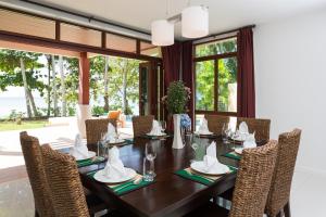 a dining room with a wooden table and chairs at Amatapura Beachfront Villa 15, SHA Certified in Ao Nam Mao