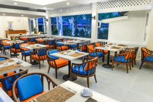 um restaurante com mesas e cadeiras e uma grande janela em Tuana Hotels Brook Pool Access em Chalong