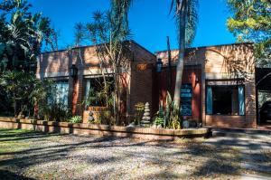 a house with palm trees in front of it at Casa Calchaqui in Yerba Buena
