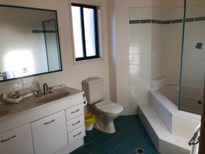 a bathroom with a toilet and a sink and a shower at Grange Resort Hervey Bay in Hervey Bay