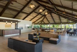 a lobby with tables and chairs and a restaurant at Solina Beach & Nature Resort in Carles