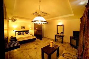 - un salon avec un lit et une table dans l'établissement Nayagara Hotel, à Chennai