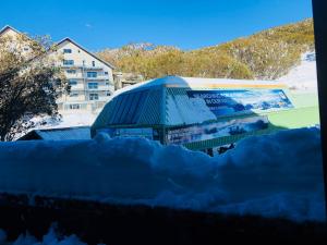 un cumulo di neve di fronte a un edificio di East 302 St Falls a Falls Creek