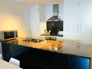 a kitchen with white cabinets and a sink and a microwave at East 302 St Falls in Falls Creek