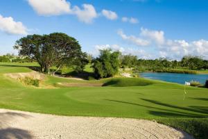 a golf course with a green and a lake at David's Place in Christ Church