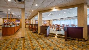 a restaurant with a dining room with tables and chairs at Best Western Plus Chicago Hillside in Hillside