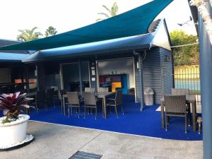 a patio with a table and chairs on a blue carpet at Grange Resort Hervey Bay in Hervey Bay