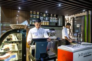 Due uomini in piedi in una cucina a preparare il cibo di Best Western Plus Maple Leaf a Dhaka