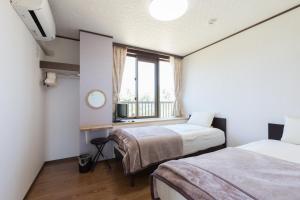 Gulta vai gultas numurā naktsmītnē Comfort House In Miyakojima