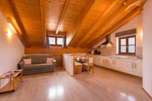 a kitchen and living room with a couch and a table at Engadiner Apartments & Wines in Montagna