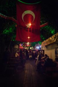 a flag hanging over a street with a crowd of people at Nur Hotel in Kaş