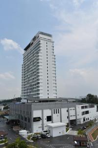 a large white building with a parking lot in front of it at Tenera Hotel in Bangi