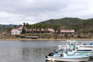 two boats docked in the water in front of a house at Okinoshima Resort Island Park Hotel in Tsudo