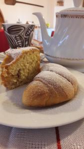 two pieces of bread on a plate with a tea pot at Dulcamara in Pescasseroli