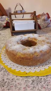 a large donut sitting on a yellow plate on a table at Dulcamara in Pescasseroli