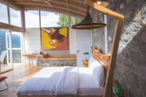 a bedroom with a bed and a stone wall at Seclude Ramgarh Cliff's edge in Rāmgarh