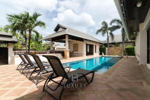 un groupe de chaises assises à côté d'une piscine dans l'établissement 4 Bedroom Private Bali Style Villa HH6, à Hua Hin