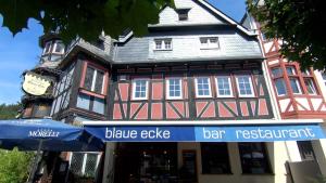 un bâtiment avec un parasol bleu et un bar-restaurant dans l'établissement Hotel Blaue Ecke, à Adenau