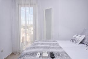 マラガにあるSeafront La Malagueta IIのベッドルーム1室(リモコン付きのベッド1台付)