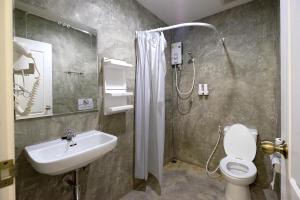 a bathroom with a shower and a sink and a toilet at Tini Kati Hostel in Bangkok