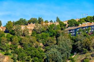 un edificio en la cima de una colina con árboles en Seafront La Malagueta II, en Málaga